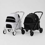 Two pet strollers shown side by side on a light gray studio background. The stroller on the left is white with black panels, and the stroller on the right is black with black panels.